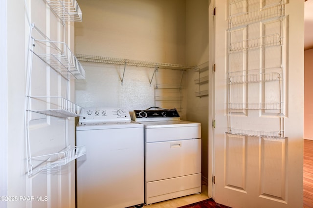 laundry room featuring washing machine and dryer and hardwood / wood-style floors