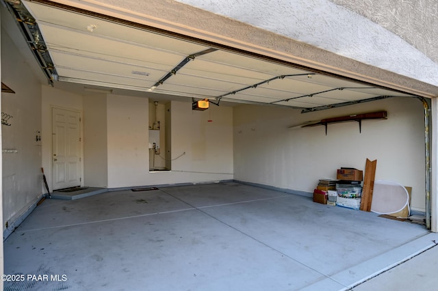 garage featuring water heater and a garage door opener