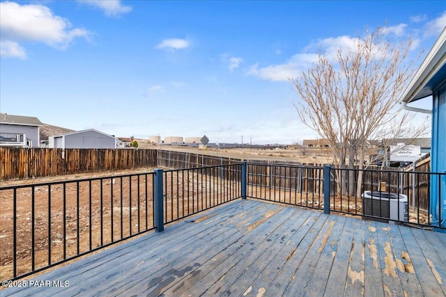 wooden terrace featuring central AC unit and a fenced backyard