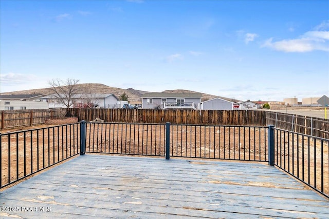 wooden deck with a mountain view and a fenced backyard