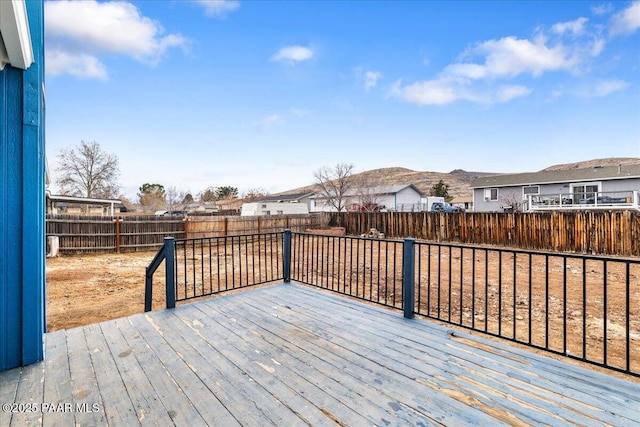 deck with a fenced backyard and a mountain view