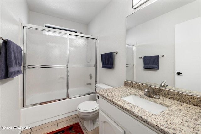 full bathroom featuring toilet, tile patterned floors, vanity, and shower / bath combination with glass door