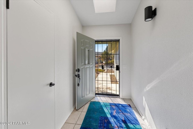 entryway featuring a skylight and light tile patterned flooring