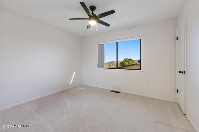 carpeted spare room featuring ceiling fan