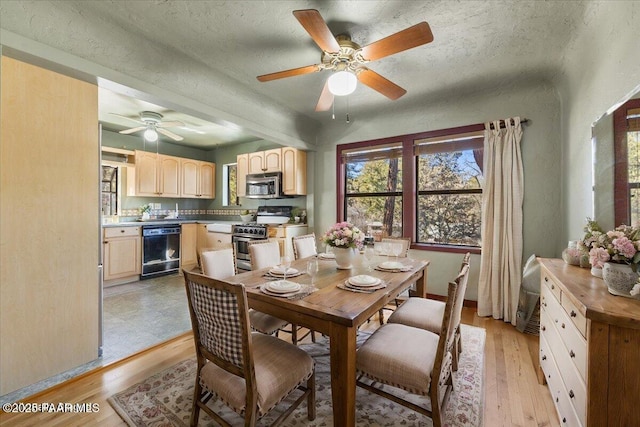 dining space with a textured ceiling and light wood-type flooring