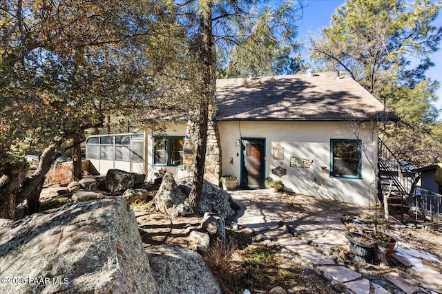 view of property exterior with a patio area and a sunroom