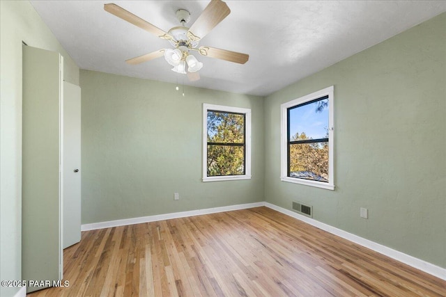 spare room with ceiling fan and light wood-type flooring