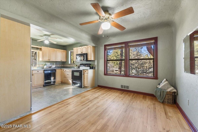 kitchen with a textured ceiling, light hardwood / wood-style floors, light brown cabinets, and black appliances