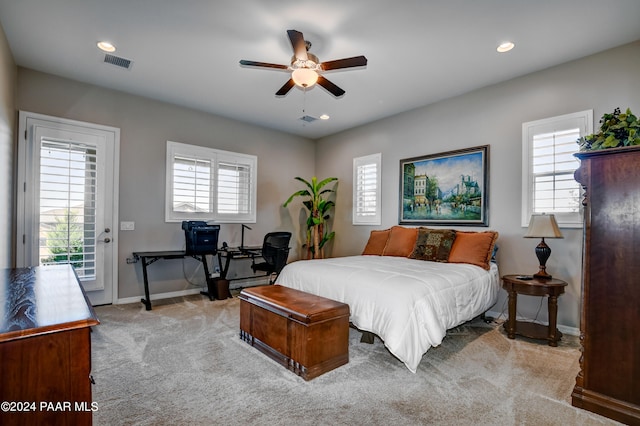 bedroom with multiple windows, light carpet, access to outside, and ceiling fan