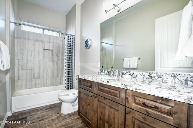 full bathroom with vanity, wood-type flooring, shower / tub combo, and toilet