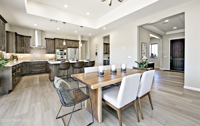 dining space featuring recessed lighting, visible vents, light wood-style floors, and a tray ceiling