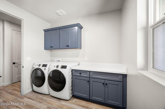 clothes washing area featuring cabinets and washer and dryer