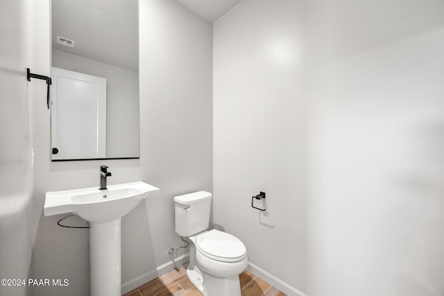 bathroom with sink, toilet, and hardwood / wood-style floors