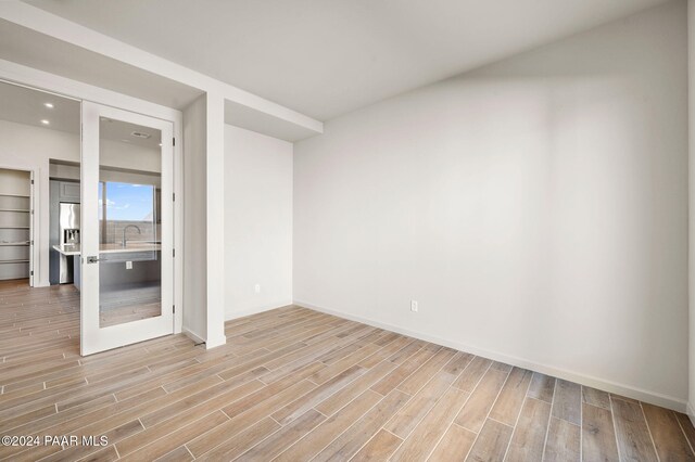 unfurnished room featuring sink and light hardwood / wood-style floors