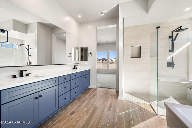 bathroom featuring tiled shower and vanity