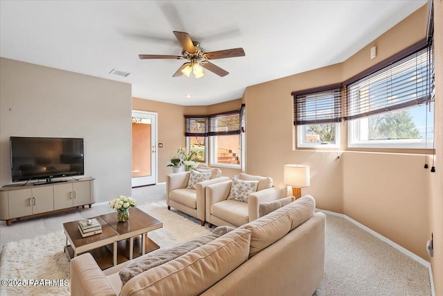 living room with light carpet, visible vents, ceiling fan, and a wealth of natural light