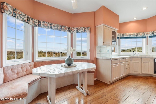 kitchen with tile countertops, recessed lighting, light wood-style flooring, and tasteful backsplash