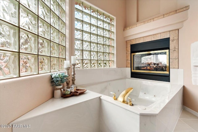 full bath with a tiled fireplace, a tub with jets, and tile patterned flooring