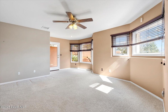 spare room featuring visible vents, baseboards, carpet, and a ceiling fan