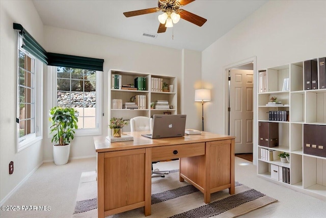 office space featuring visible vents, light carpet, baseboards, ceiling fan, and vaulted ceiling