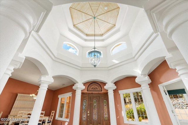 entryway featuring an inviting chandelier and a towering ceiling