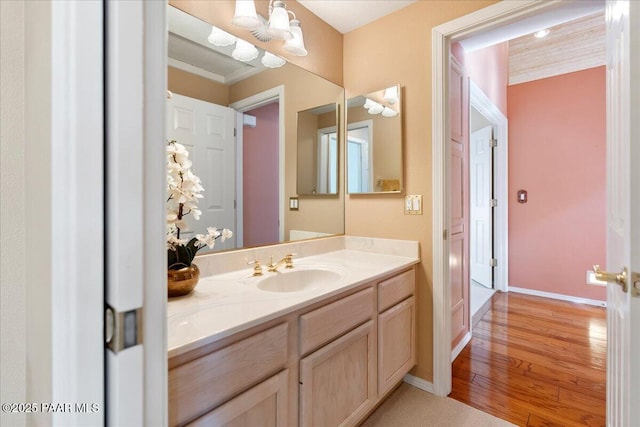 bathroom with vanity, baseboards, and wood finished floors