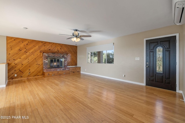2615 W Red Tail Way, Prescott, AZ 86305 - unfurnished living room with ceiling fan, baseboards, a wall mounted AC, light wood-style flooring, and wooden walls