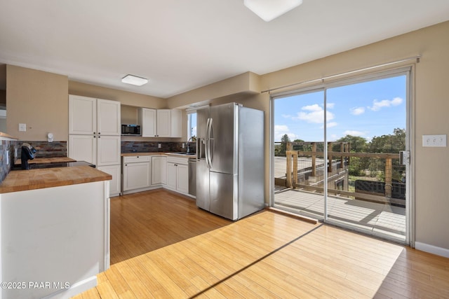 2615 W Red Tail Way, Prescott, AZ 86305 - kitchen with stainless steel appliances, light wood-type flooring, a sink, white cabinetry, and wood counters