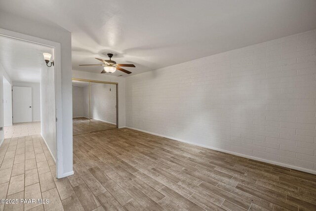 2615 W Red Tail Way, Prescott, AZ 86305 - empty room featuring brick wall, wood finished floors, a ceiling fan, and baseboards