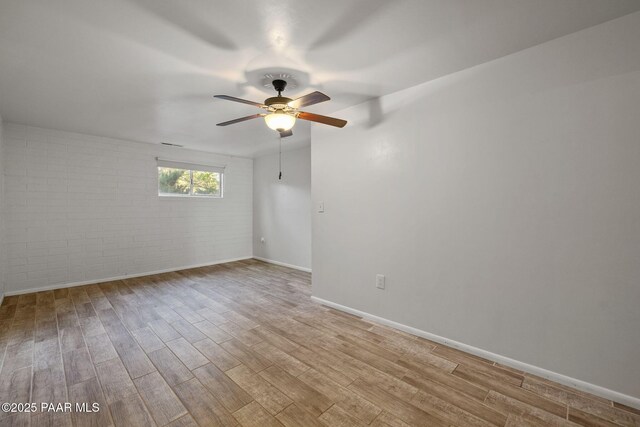 2615 W Red Tail Way, Prescott, AZ 86305 - empty room featuring brick wall, light wood-style flooring, baseboards, and a ceiling fan
