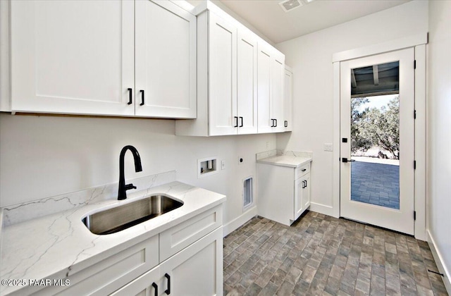 laundry room featuring hookup for a washing machine, a sink, hookup for an electric dryer, cabinet space, and brick patterned floor