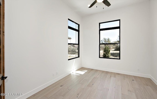 empty room featuring ceiling fan, baseboards, and light wood-type flooring