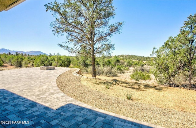 view of yard featuring a patio area, a fire pit, and a mountain view