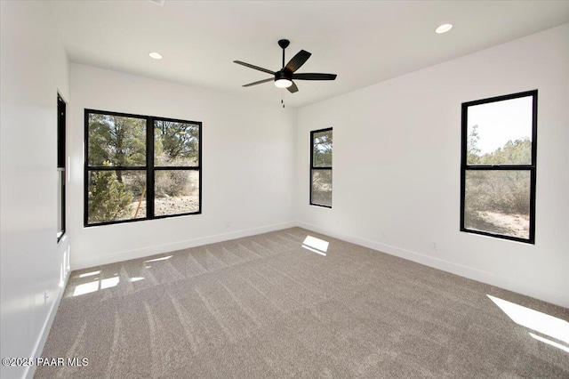 spare room with baseboards, a ceiling fan, and carpet