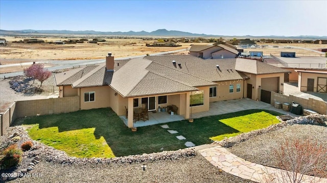 back of property with stucco siding, a patio, a fenced backyard, and a mountain view
