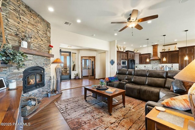 living room featuring visible vents, ceiling fan, recessed lighting, a fireplace, and wood finished floors