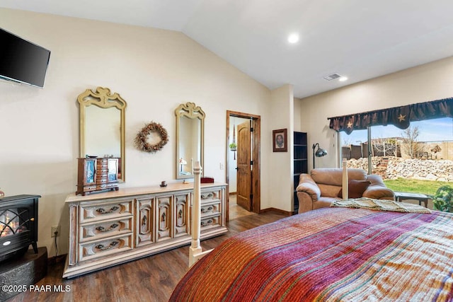 bedroom with wood finished floors, visible vents, a wood stove, access to exterior, and vaulted ceiling