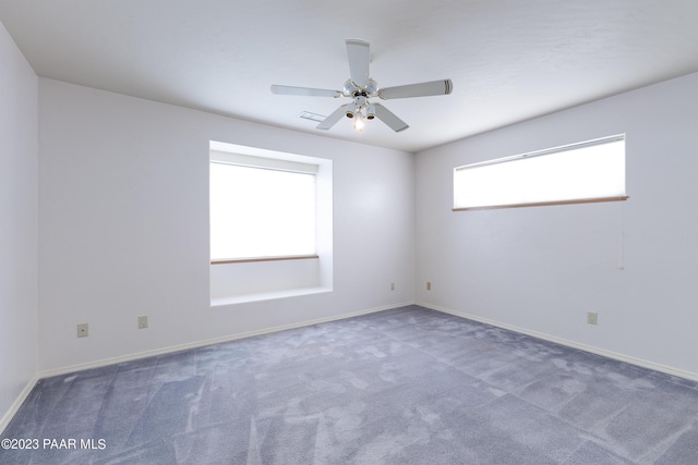 unfurnished room featuring ceiling fan and dark carpet