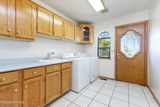 laundry area featuring cabinets, separate washer and dryer, sink, and light tile patterned floors