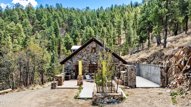 4555 E Combination Ln, Prescott, AZ 86303 - rustic home with a forest view, a patio, and stone siding