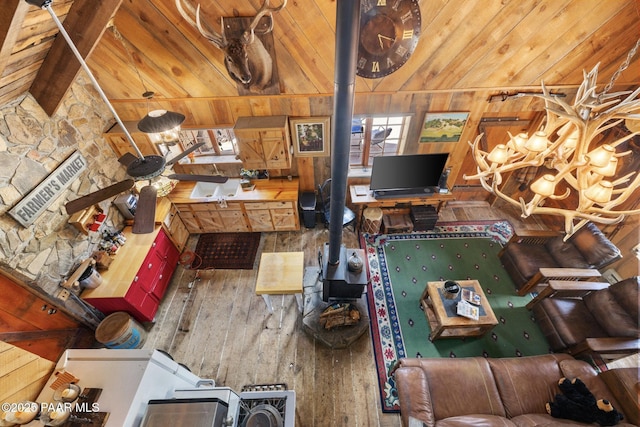 4555 E Combination Ln, Prescott, AZ 86303 - living area with wooden ceiling, a wood stove, wood walls, and hardwood / wood-style flooring