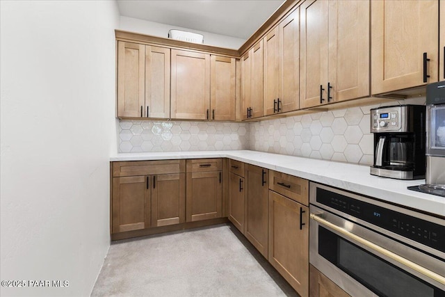 kitchen featuring oven, tasteful backsplash, and light stone countertops