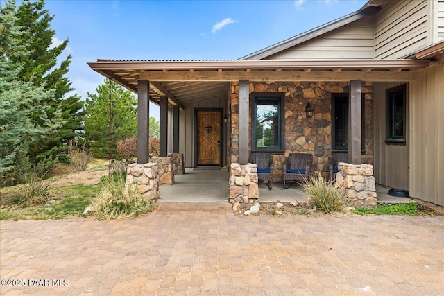 entrance to property featuring stone siding and covered porch