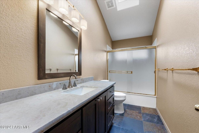 414 N Fitzmaurice Dr, Prescott, AZ 86303 - bathroom featuring toilet, vanity, enclosed tub / shower combo, a textured wall, and stone tile floors