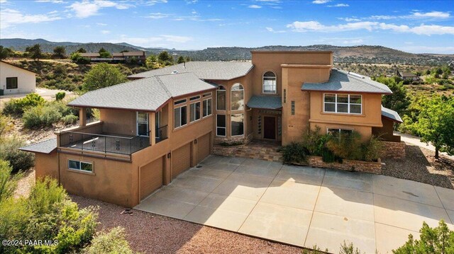 414 N Fitzmaurice Dr, Prescott, AZ 86303 - rear view of house with driveway, stucco siding, a balcony, a garage, and a mountain view