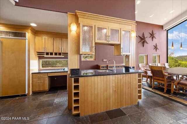 414 N Fitzmaurice Dr, Prescott, AZ 86303 - kitchen with paneled fridge, a sink, stone tile floors, and glass insert cabinets