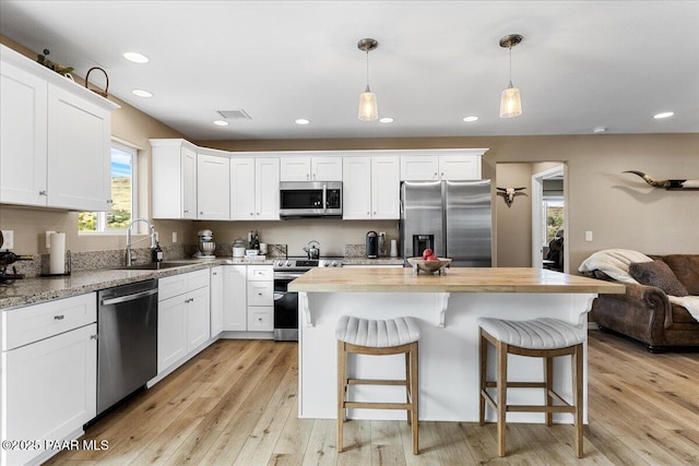 1720 N Topaz Rd, Prescott, AZ 86301 - kitchen with stainless steel appliances, a sink, light wood finished floors, open floor plan, and white cabinets