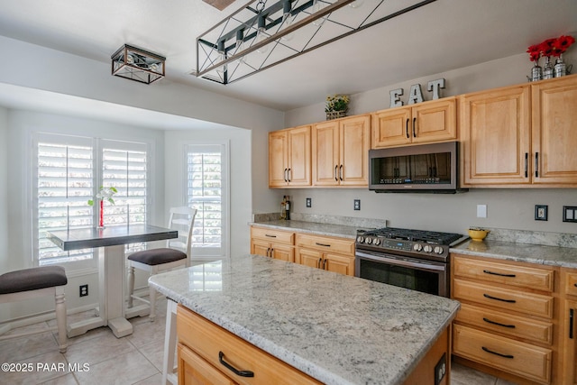 596 N Mohave Trl, Dewey-Humboldt, AZ 86327 - kitchen with appliances with stainless steel finishes, light brown cabinets, light tile patterned floors, a kitchen island, and light stone counters