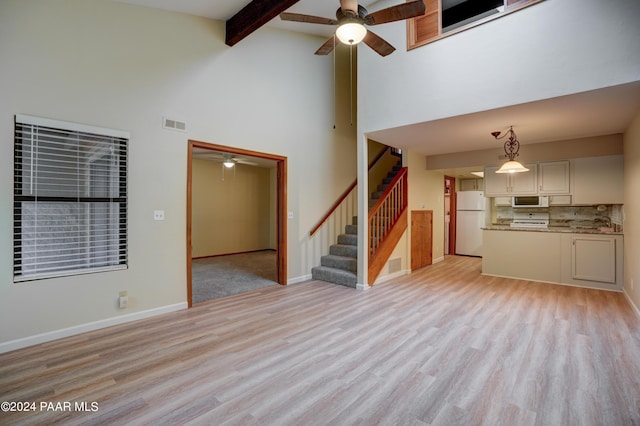 253 Creekside Cir Unit B, Prescott, AZ 86303 - unfurnished living room featuring stairway, light wood-style flooring, ceiling fan, baseboards, and a high ceiling