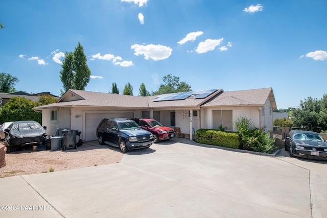 ranch-style home with solar panels and a garage